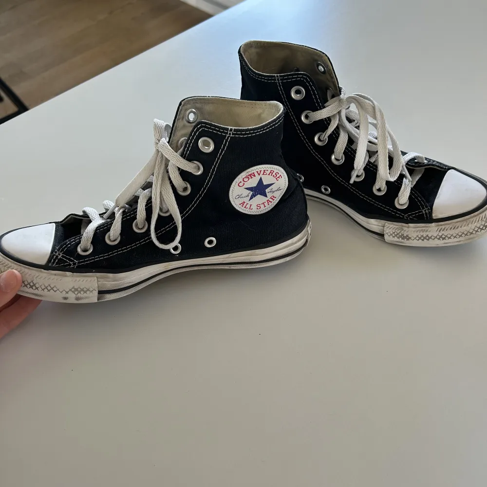 Ett par svarta Converse. Skor.