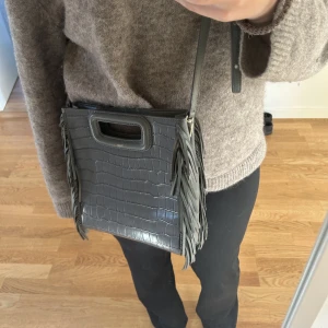 Maje väska - Säljer denna sååå snygga maje väska! Super fint skick och nästintill oanvänd, köpt på maje på nk👌 nypris cirka 3000kr💕 skriv för fler bilder eller vid frågor💞