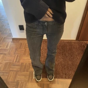 Grå långmidjade bootcut jeans - Säljer dessa grå lågmidjade jeans ifrån Brandy Melville. De är uppsydda så de passar mig som är 168 cm. (Första bilden är lånad men resten är mina egna)