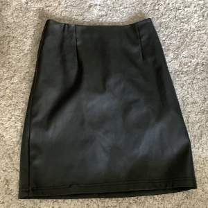 Svart miniläderkjol - Fake svart läderkjol från Asos i xs/S. Använd 2ggr.