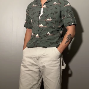 Mörk grön kortärmad skjorta med mönster - Skjorta från UNIQLO med bra ventilerande material, storlek S och använd ett par gånger men är fortfarande i mycket bra skick