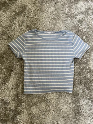 Randig t-shirt - Fin blå randig t-shirt från lager 157. Jätteskönt material och lite kroppad. Storlek M, men ganska liten i storleken.
