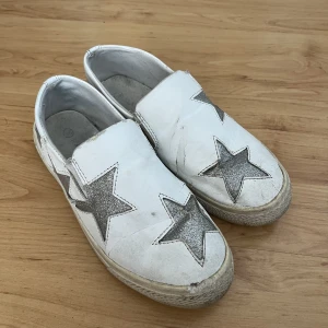 Skor - Skor i använt skick. Fina slipons med glittriga stjärnor 
