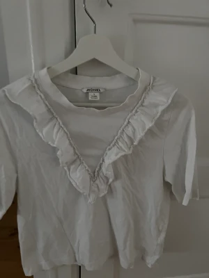 T-shirt med volang  - Lite sliten men sitter snyggt när man bär den. 