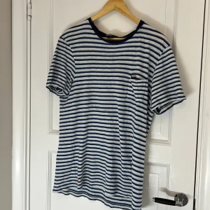 Vit och blå randig ralph lauren tshirt - Perfekt för sommaren, helt okej skick och vintage. Har fått den av min pappa som inte använder den längre (samt jag) skriv för frågor/bilder