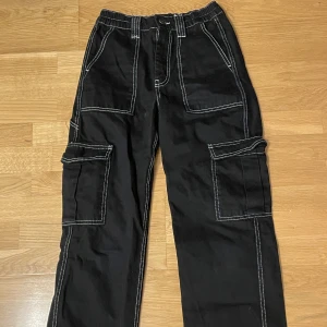 Svarta cargobyxor  - Svarta cargobyxor från Urban Outfitters. Storlek W26 L30