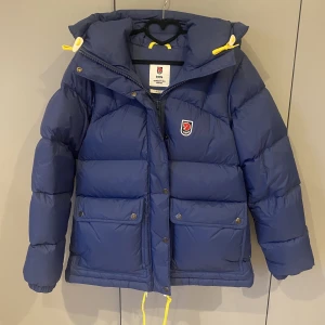Fjällräven jacka - Marinblå fjällräven jacka i super fint skick, köptes för 2 år sen på Naturkompaniet och användes ett fåtal gånger den vintern. Har annars inte haft den sen dess, nu är den lite liten för mig. Det är en Expedition Down Lite jacket. Kvittot finns vid behov!