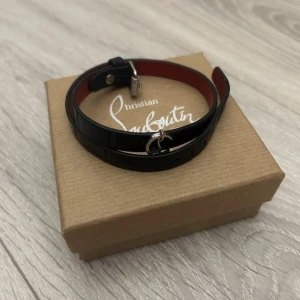 Christian Louboutin armband - Ett skit snyggt armband från Christian Louboutin i mörkblått läder. Armbandet är one size och passar alla. Armbandet är i bra skickoch låda, dustbag och tags följer me. Självklart äkta, kan också byta mot valentino armband betoende på skick och färg.