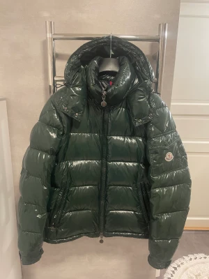 Moncler Maya - Säljer denna feta moncler maya jacka, size 2 vilket motsvarar M ungefär, jackan är i bra skick saknar cartoon och har en del vattenfläckar men syns ej vid användning! 