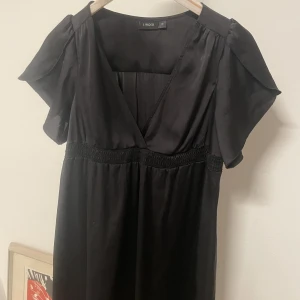 Svart klänning - Jättesöt miniklänning köpt second hand. Säljer då den inte passar mig💔 Glansig och perfekt till fester. Skriv för fler bilder!