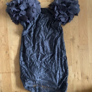 Klänning med fluffiga axelvaddar  - Grå klänning med fluffiga axelvaddar. Aldrig använd så är som ny. Skriv privat för fler bilder.