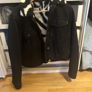 Fodrad jeansjacka  - En svart jeansjacka med mönstrad insida från Bershka. Flitigt använd och inga defekter. Köpt för 800 ungefär. 