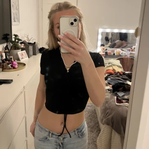 Svart croptop/t-shirt - Säljer denna svarta croptopen/t-shirten från H&M Divided då den inte kommer till användning. Den går att justera med band vid magen💗