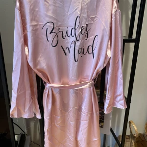 Två morgonrockar i stl S/M - Säljer mina morgonrockar i storlek S. Två exakt likadana säljs tillsammans. Med ”Brides Maids” som text. Använda två gånger vid en möhippa. Materialet är som silke. Låg på vinden ett tag, är varför dem är skrynkliga. Men blir jättefina när man stryker. 
