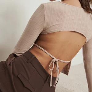 Beige topp med öppen rygg - Topp i stretchigt material med öppen rygg knyter man tightare så blir toppen mer firgurnära, helt ny 😊