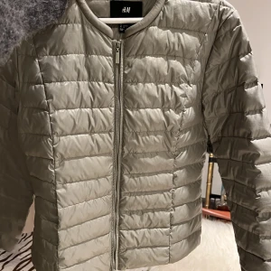 Dunjacka - Grå-grön dunjacka. 