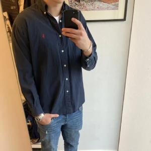 Mörkblå Ralph Lauren skjorta  - Mörkblå Ralph Lauren skjorta i storlek S men passar mer som M. Skicket är 8/10 med inga tydliga defekter. Priset är förhandlingsbart