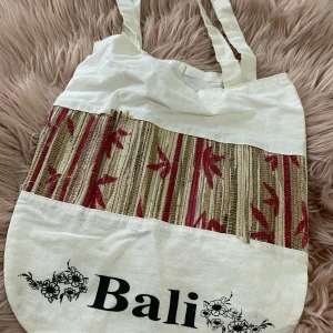 Tygkasse Bali - En jättefin tygkasse från Bali. Jag använde den inte så mycket, men den gången jag använde den så var det i regnet och eftersom att väskan är gjord av naturliga material från Bali så blev den lite förstörd (bifogar bild). Samfraktar gärna.