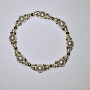 Vit och guld-armband  - Vita akrylpärlor, mindre guldpärlor med guld detaljer. 