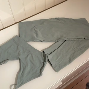 Träningskläder  - Ett fint grågrönt tränings set med topp och byxor. Helt oanvänt. Toppen är i XS/S och byxorna i M/L. 