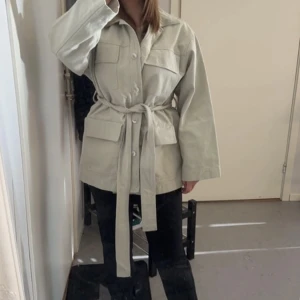 Jacka - En trenchcoat i en slags ljusgrön färg. Har använts 3-4 gånger men är i väldigt fint skick. Säljer på grund av att den aldrig kommer till användning tyvärr.