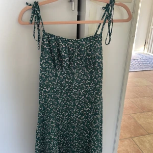 Kort grön blommig klänning  - Kort grön blommig vardags klänning som bara används 2 gånger 