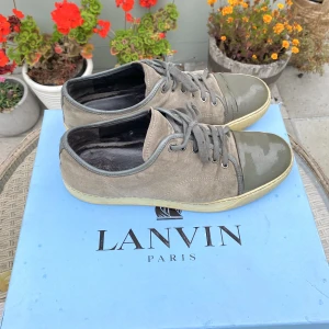 Lanvin Patent Cap Toe Sneaker Grey - Hejsan, säljer ett par väldigt stilrena Lanvin Cap Toe Sneakers i grå färg. Size 9 vilket motsvarar 43/44. Bra skick förutom lite crack på vänster tå, kom DM för bild. Beige toebox och snygg färgkombo. Nypris runt 4300kr. Pris kan diskuteras. Hör av dig! 