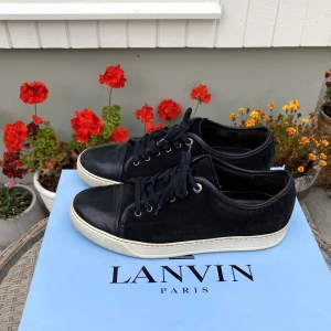 Lanvin Patent Cap Toe Sneaker Svart - Hej, säljer ett par av de väldigt populära Lanvin Cap Toe Sneaker i svart. Både mocka och ToeBox i utmärkt skick. Size 8=42/43. Nypris runt 4300. Sparsamt använda. Neutral färg och passar till det allt, den perfekta skon. Pris kan diskuteras. Hör av dig! 