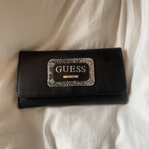 Guess plånbok - Guess plånbok med nitar på, bra skick. Den är ej fake, köpte den för något år sen sen inte kommit till användning.