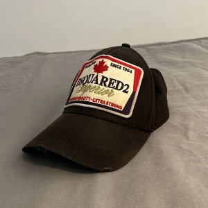 Dsquared2 keps - Säljer min dsquared2 keps som är i skicket 8,5/10 jag har använt den men den är fortfarande i bra skick och kan användas mer längre fram. Jag köpte den på NK för 1900 kr men mitt pris är 350 kr. Hör av er vid minsta frågor!