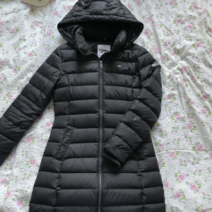 Tommy Hilfiger Down Coat  - Lång Tommy Hilfiger dunjacka. Köpt för 3199kr. Använd en vinter, i gott skick från rök och djurfritt hem. Hör av er om ni vill ha fler bilder eller frågor. Kan antingen frakta eller mötas upp i Stockholm. 