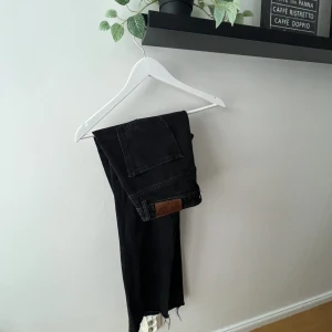 Svarta Jeans - Lätt urtvättad svart färg från NA-KD med en sliten design i byxändarna. Mellanhög midja. 