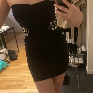 Festklänning - Jättefin liten bandeau festklänning med glittriga stenar på sidorna. Aldrig använd, från Jane Norman. Perfekt till nyår! 