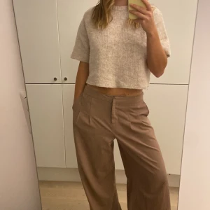 Stickad kortärmad tröja - Så fin stickad kortärmad tröja i en snygg ljus beige färg. Rak i modellen 