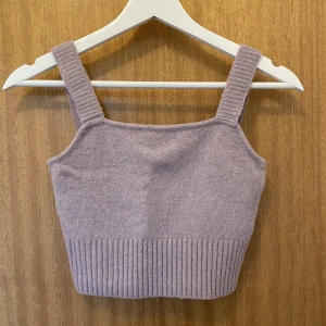 Stickat lila linne från H&M - Lila croppat linne i stickat material i strl S. Använd och lite nopprig men annars fin