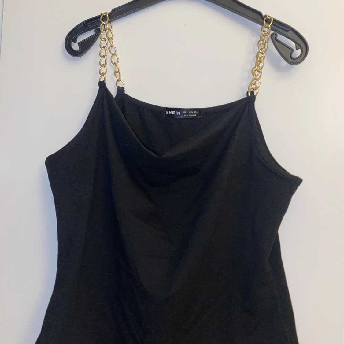 Svart linne med guldkedjor