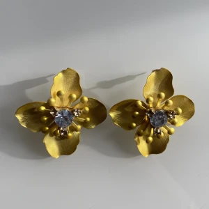 Fina gula örhängen💛 - Säljer dessa örhängen med gul blomma och sten i mitten. Knappt använda och i väldigt fint skick☺️