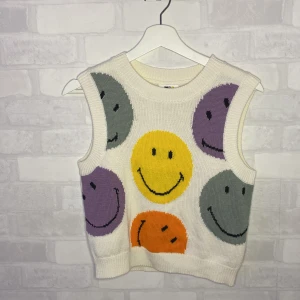 Smiley väst! - En stickad smiley väst i alla möjliga färger! Passar bra till skjorta. Storlek S. HELT OANVÄND!!!