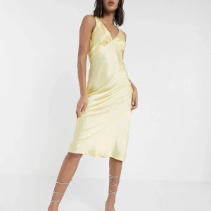 Gul satinklänning i strl 36 - Citrongul midiklänning i satin strl. 36. Oanvänd.
