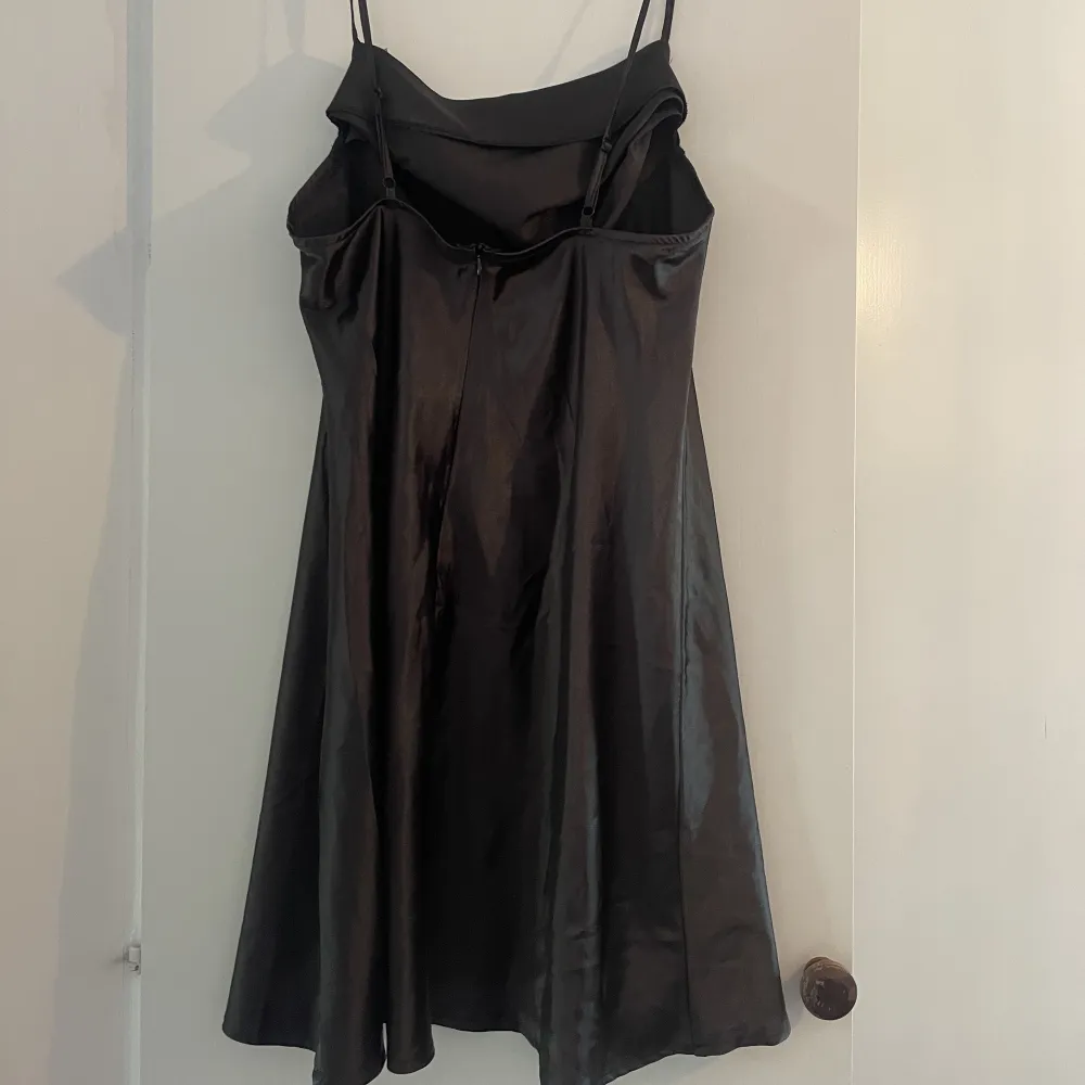 Säljer denna svarta silkesklänning i storlek XL men den är liten i storleken. Aldrig använd.. Klänningar.