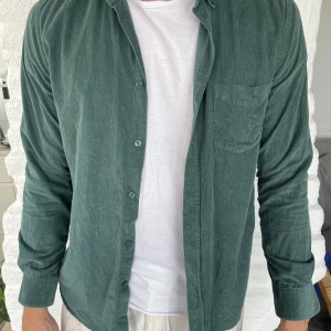 Grön Overshirt - Jättefin overshirt i manchestertyg. Varan är i mycket bra skick inga slitningar. Säljer den pågrund av att den är för liten.