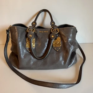 miu miu handväska - jättesnygg miu miu handväska i nästan perfekt skick. mörkgrå färg. skriv för frågor 🩷