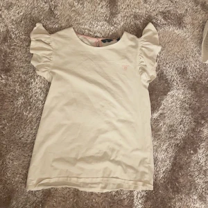 Volang tröja - Vit tröja me volang ärmar skön och fint skick, rosa gant text passar 12-15 år men det står 15 år 