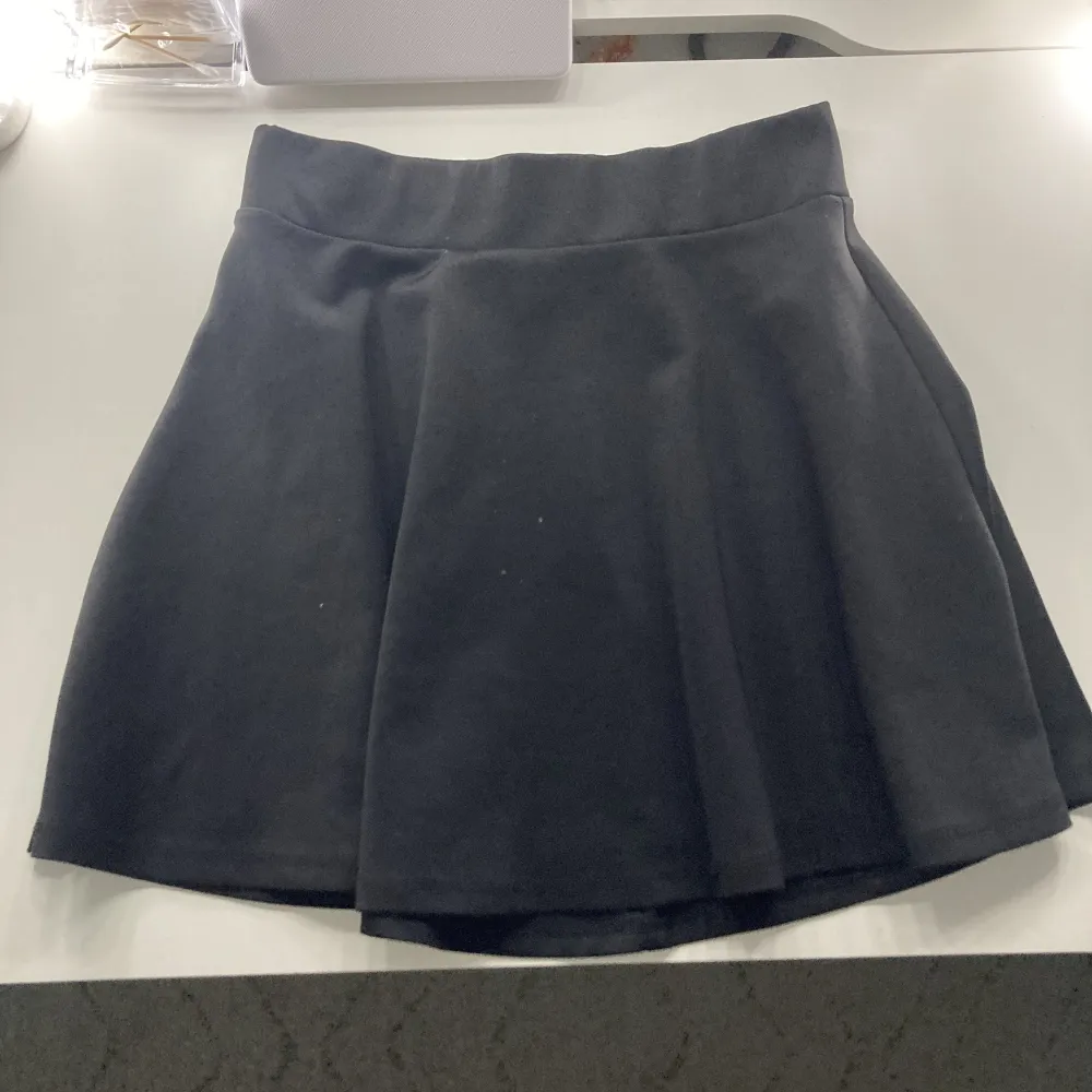 En kort svart kjol från Kappahl. Använd rätt mycket men fortfarande i bra skick. Säljs pga börjar bli för liten. Storlek 146/152. Kjolar.