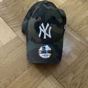 Keps Militärmönster - En keps använd få gånger med lappen på skärmen kvar, i militär mönster 