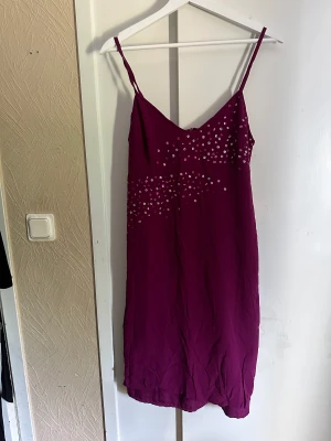 Vintage klänning med detaljer - Lila klänning med fina paljetter. Perfekt för sommaren, enkel men färgglad sitter fint på. Storlek 44, fint skick.  