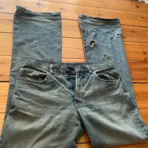 Vintage SPF Bootcut jeans Eur 31, med små hål vid botten av byxorna.