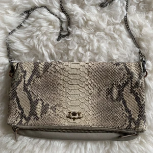 Zadig&Voltaire Väska  - Köpte väskan 2018 för ungefär 2000kr. Den är i fake orm skinn material. Använt mycket men är i bra skick! 