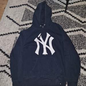 En mörkblå New York Yankees hoodie. Storleken är Small men funkar lika bra om du har M. Nypris 599 kr