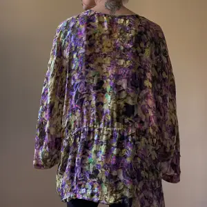 Preloved Designer Roberto Cavalli V-Neck Top with Flowy Sleeves. Adjustable Drawstring at Waist. Multicolor Floral Print. Made in Italy. Hologram Label for Authenticity.  Excellent Condition.  Relaxed Fit. Best Fits M/L. Orig Tagged Size 38.